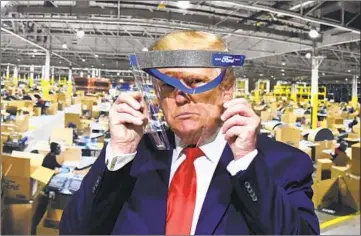  ?? Daniel Mears Associated Press ?? looks through a face shield while touring a Ford Motor Co. plant in May. PRESIDENT TRUMP