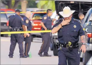  ?? DAVID J. PHILLIP/THE ASSOCIATED PRESS ?? Harris County Sheriff’s Office Sgt. D.J. Hilborn walks away from the scene of a shooting Sunday in Houston. Eight people, including six children, were found dead inside a home.