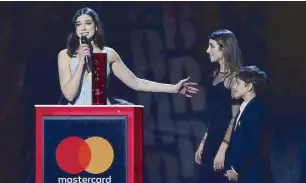  ??  ?? Dua Lipa (left) introduces her young brother and sister to the audience as she accepts the award for British Breakthrou­gh Act