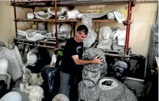  ?? AP ?? Jorge Grimaz holds a bust of Argentine General Martin Miguel de Guemes at a statue hospital Argentina.