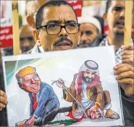  ?? Hassene Dridi ?? The Associated Press A protester holds a poster showing Saudi Crown Prince Mohammed bin Salman and President Donald Trump on Tuesday in Tunis, Tunisia.