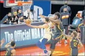  ??  ?? The 76ers’ Ben Simmons (25) drives to the hoop against Warriors James Wiseman (33) and Kelly Oubre Jr. (12) in the fourth quarter of their March 23 game at Chase Center in San Francisco.