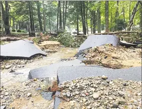  ?? Matthew Cassenti photo ?? The old stone bridge over Neptune Brook in East Haddam was breached when the water caused by heavy rains Tuesday night, combined with debris, formed a temporary dam that burst. Portions of the asphalt on Neptune Avenue broke into chunks from the water’s force.