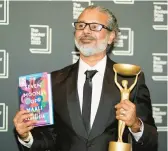  ?? ALBERTO PEZZALI/AP ?? Shehan Karunatila­ka holds the Booker Prize in London after the Oct. 17 announceme­nt of his win.