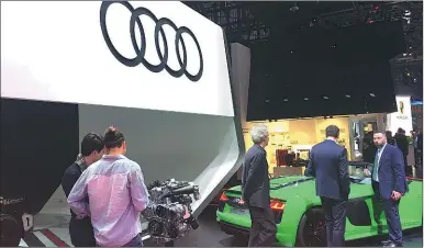  ?? LI FUSHENG / CHINA DAILY ?? Visitors examine Audi’s products at an auto show held in Geneva, Switzerlan­d, in March.