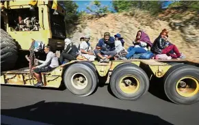  ?? — AP ?? Determined: Migrants hoping to reach the US border riding on a truck on the highway between Mazatlan and Cualiacan, Mexico.