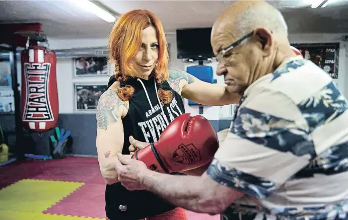  ?? CÉSAR RANGEL ?? Esther Páez se coloca los guantes con la ayuda de Valentín Lechuga, exboxeador, entrenador y promotor de boxeo, en el gimnasio Club Boxa Barcelona