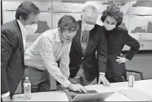  ?? ASSOCIATED PRESS] ?? Republican Senate candidate Sen. Mitch McConnell, second from right, and his wife, Elaine Chao, right, look on as aides show him the election results Tuesday in Louisville, Ky. [TIMOTHY D. EASLEY/ THE