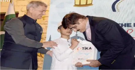  ?? ?? Karachi: Sindh Chief Minister Murad Ali Shah along with Turkish Consul General Kemal Sango distributi­ng Eid gifts to orphans and special children at the Turkish Consulate. — NNI