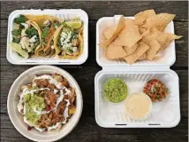  ?? WENDELL BROCK FOR THE ATLANTA JOURNAL- CONSTITUTI­ON ?? This takeout spread from the Queso Truck includes ( clockwise from upper lef t): chicken, carne asada and pork belly tacos; queso, salsa, guacamole and house- made chips; loaded tots with pork belly.