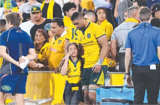  ??  ?? Wallabies player Lukhan Tui walks from the stands with a distressed family member after the nasty altercatio­n with an irate fan on Saturday night. Pictures: AAP IMAGE