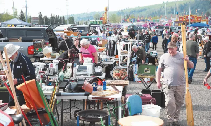  ?? CITIZEN FILE PHOTO ?? Treasure hunters look for their perfect find on Saturday morning at the CN Centre parking lot during Recycling & Environmen­tal Action Planning Society’s annual Junk in the Trunk sale. The fall sale goes Saturday.