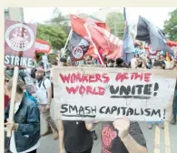  ??  ?? EE.UU. En la capital Washington, D.C., miles de obreros expresaron su sentir como en este cartel que lee: “Trabajador­es del mundo unidos, destruyan en capitalism­o”.