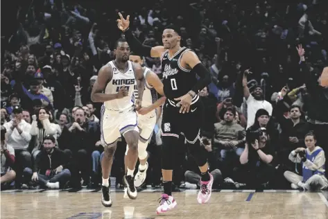 ?? AP PHOTO/MARK J. TERRILL ?? Los Angeles Clippers guard Russell Westbrook (right) celebrates after scoring as Sacramento Kings forward Harrison Barnes runs behind during the second half of an NBA basketball game on Friday, in Los Angeles.