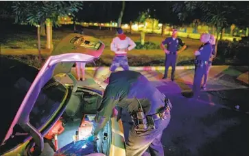  ?? Marcus Yam Los Angeles Times ?? OFFICERS with LAPD’s elite Metropolit­an Division stop a driver and search a vehicle in Los Angeles in 2015.