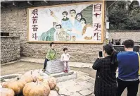  ?? BRYAN DENTON FOR THE NEW YORK TIMES ?? Parents photograph­ing their children in front of where it is said Xi Jinping lived during the Cultural Revolution.