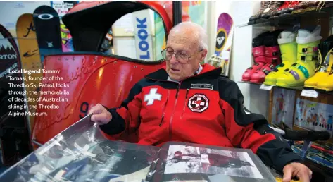  ??  ?? Local legend Tommy Tomasi, founder of the Thredbo Ski Patrol, looks through the memorabili­a of decades of Australian skiing in the Thredbo Alpine Museum.