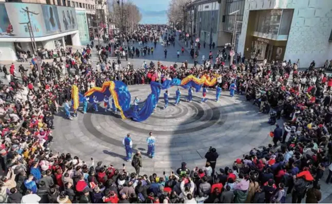  ?? ?? A dragon dance at Hubin Road drew a large crowd of spectators during the Chinese New Year holiday in Hangzhou. — Photos / Ti Gong