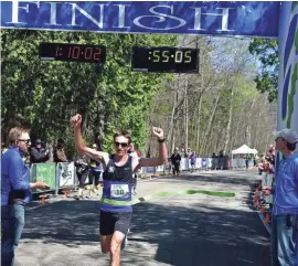  ?? LEN VILLANO ?? Tyler Sigl crosses the finish line as the winner of the Door County Half Marathon.