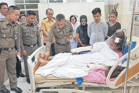  ?? PHOTOS BY POLICE ?? Deputy police chief Wirachai Songmetta, centre left, looks at injuries suffered by Kuldara Yeesaman, 21, at Nopparatra­jathanee Hospital in Bangkok yesterday. Chaichana Sirichart, below left, is believed to have used an iron, knives, a hair...