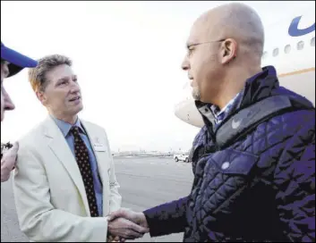  ?? Rick Scuteri The Associated Press ?? Mike Nealy, left, who runs the Fiesta Bowl in Glendale, Ariz., and the Guaranteed Rate Bowl in Phoenix, is hoping normalcy returns for both games. This season’s Fiesta Bowl was played without fans, and the Guaranteed Rate Bowl was canceled.