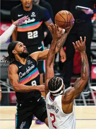  ?? Ashley Landis / Associated Press ?? Patty Mills, rising above Kawhi Leonard, scored a season-high 27 points late Tuesday in a victory over the Clippers.