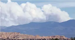  ?? LUIS SÁNCHEZ SATURNO THE NEW MEXICAN ?? The smoke plume from the Hermits Peak/Calf Canyon Fire can be seen over the Sangre de Cristo Mountains from Española on Wednesday. The blaze had scorched nearly 237,000 acres by Wednesday morning. The Whitewater-Baldy Complex Fire in the Gila Mountains in 2012 is the state’s largest at 297,845 acres.