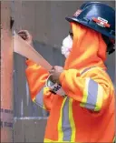  ?? The Canadian Press ?? A workman applies tape to a temporary hallway to the COVID-19 testing centre at Mt. Sinai Hospital in Toronto on Thursday.