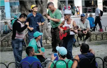  ?? RAMON ESPINOSA/THE ASSOCIATED PRESS ?? Constructi­on workers dance and sing as they wait for a bus in Havana on Wednesday.