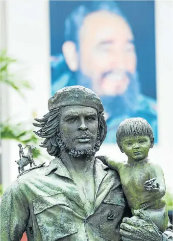  ?? Picture: 123rf.com/adamico ?? IRON GRIP The Statue of Che Guevara Holding a Child in Santa Clara, Cuba. In the background is an image of Fidel Castro.