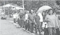  ??  ?? Manyin (fourth right) joins the villagers as they walk from the church to the parish hall after the Sunday mass.