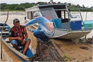  ??  ?? LUIS ALVES
Nogueira, de 74 años, recibe la vacuna de Oxford-astrazenec­a contra el Covid-19 sin bajarse de su bote en Labrea