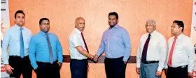  ??  ?? Siyapatha Finance Managing Director Ananda Seneviratn­e and Indra Traders Director Hasindra Kumara Silva sign the MOU while other senior officials of both organisati­ons grace the ceremony