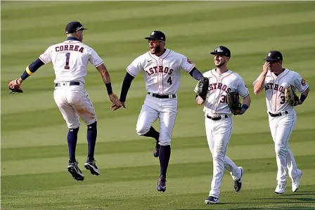 ?? AP Photo/Ashley Landis ?? ■ Houston Astros' Carlos Correa, from left, celebrates with George Springer, Kyle Tucker and Myles Straw after the Astros defeated the Oakland Athletics on Thursday in Game 4 of a baseball American League Division Series in Los Angeles.