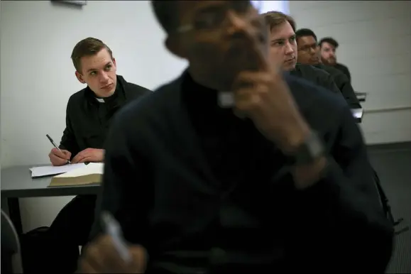  ?? WONG MAYE-E — THE ASSOCIATED PRESS ?? Seminarian Daniel Rice, left, sits with classmates during a lesson on the Gospel of Luke at St. Charles Borromeo Seminary in Wynnewood, Pa., on Feb. 5. Future Catholic priests remain unflinchin­gly optimistic despite scandals that have driven faithful from the pews.