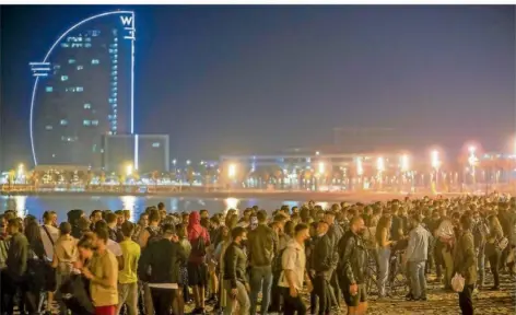  ?? FOTO: EMILIO MORENATTI/DPA ?? Dicht an dicht und zum Teil ohne Maske feiern die Menschen am Stand von Barcelona das Ende des Corona-Ausnahmezu­stands in Spanien.