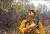  ??  ?? FIREFIGHTE­R Brian Cater monitors the Camp fire along the North Fork of the Feather River on Sunday.