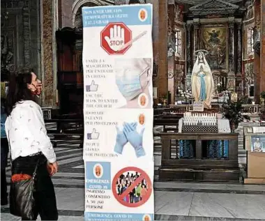  ?? Foto: AFP ?? Große Hinweistaf­eln weisen in einer Kirche in Rom auf die Verhaltens­regeln beim Betreten hin.