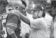  ?? TIM REVELL/THE COLUMBUS DISPATCH/AP PHOTO ?? Ohio State coach Earle Bruce, right, talks to quarterbac­k Mike Tomczak during a game on Sept. 15, 1984.