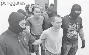  ??  ?? KEEMPAT-EMPAT tertuduh diiringi anggota polis Bahagian Anti Pengganas (E8) Cawangan Khas Sabah keluar dari Mahkamah Tinggi selepas dijatuhkan hukuman.