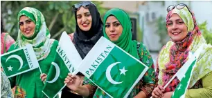  ?? Photos by Ryan Lim ?? Pakistani women and (below) schoolchil­dren hold national flags during Pakistan Day celebratio­n at the embassy in Abu Dhabi on Thursday. —