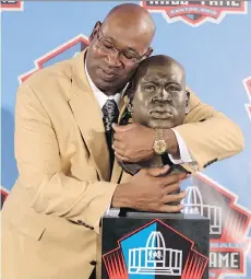  ?? THE ASSOCIATED PRESS/FILE ?? Cortez Kennedy hugs his bust at the induction ceremony at the Pro Football Hall of Fame in Canton, Ohio.