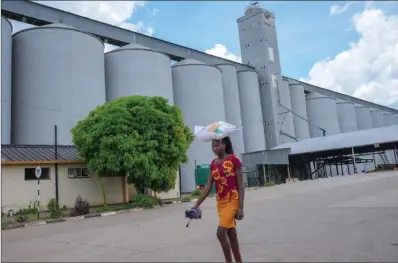  ?? ?? A woman walks past Grain Marketing Board silos in Lions Den recently. Government says there is inadequate maize in stock to meet the country’s needs before harvesting in April.