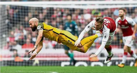  ??  ?? Free fall: Brighton’s Bruno Saltor (left) and Arsenal’s Aaron Ramsey go tumbling at the Emirates. — Reuters