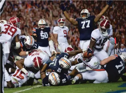  ??  ?? Auburn running back Kerryon Johnson reaches over the goal line for the go- ahead touchdown in the Iron Bowl. | ALBERT CESARE/ AP