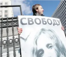  ?? EVGENY FELDMAN/AFP/Get ty Imag es ?? A protester holds a picture of one of the jailed members of the all-girl punk band Pussy Riot under the word “Freedom.”