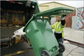  ?? THE ASSOCIATED PRESS ?? In this photo taken Thursday, Oct. 27, 2016, apprentice garbage man Corey Lever collects trash outside a school in Oakland, Calif. A new partnershi­p between Waste Management of Alameda County Inc., the nonprofit Oakland Civicorps and unions gives young...