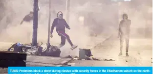  ?? — AFP ?? TUNIS: Protesters block a street during clashes with security forces in the Ettadhamen suburb on the northweste­rn outskirts of the capital on Sunday.