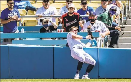  ?? Robert Gauthier Los Angeles Times ?? FANS WATCH AS Zach McKinstry catches a foul ball while crashing into the wall during Friday’s 1-0 victory over Washington.