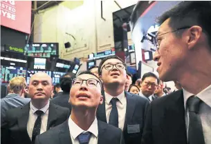  ?? SPENCER PLATT/GETTY IMAGES ?? Traders and employees of Beijing-based Sunlands Online Education gather at the New York Stock Exchange during an IPO one day after massive market losses from fears of a U.S.-China trade war.